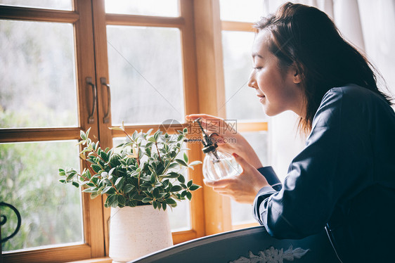 给植物浇水的居家女性图片