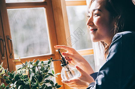 给植物浇水的居家女性图片