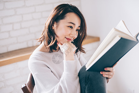 坐着椅子的女人在阅读图片