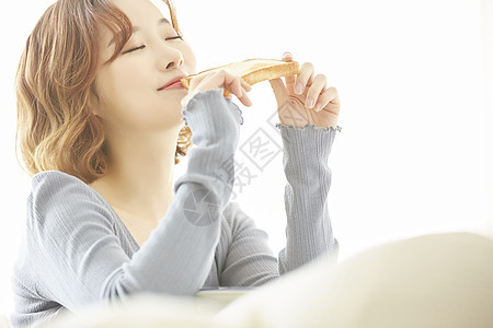 早餐吃着土司的年轻女子图片