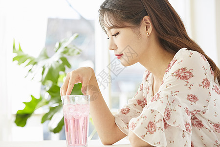 低头看着果汁的女青年图片