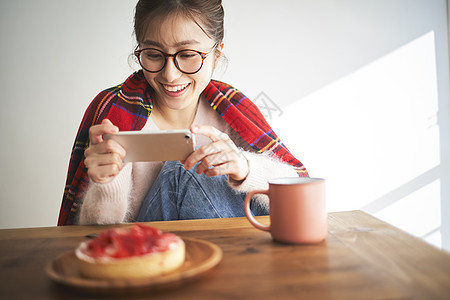 美丽的女人在家拍美食图片