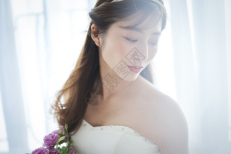 穿着婚纱手拿捧花的新娘背景图片