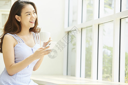 下午茶喝咖啡的年轻女子图片