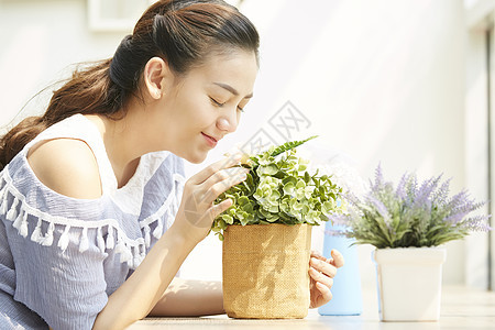 阳台闻花香的女孩图片