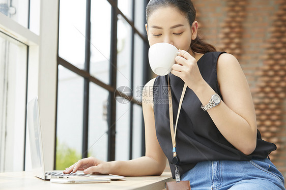 户内商务女性喝咖啡办公图片