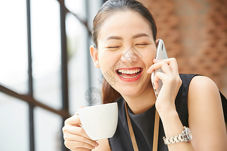 坐在窗台边上接打电话的女性图片