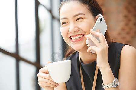 坐在窗台边上接打电话的女性图片