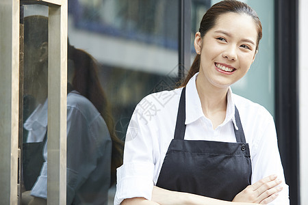 站在咖啡厅门口微笑的咖啡店店员图片