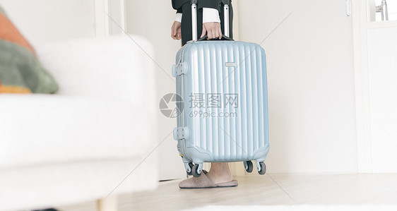 拿着行李箱出门的职业女性图片