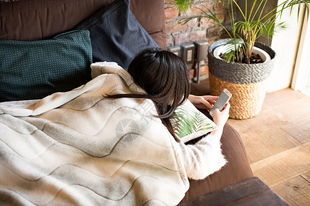 趴着玩手机的女青年图片素材
