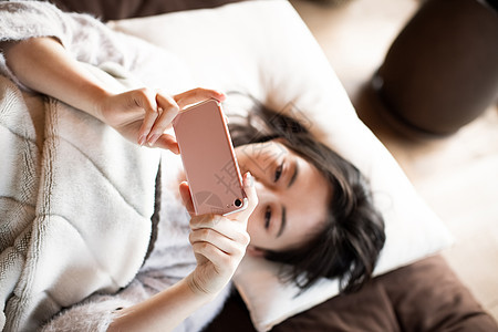 室内看着智能手机的女人图片