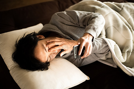 男人躺着看智能手机生活方式图片素材
