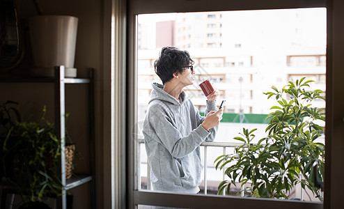 男人看着智能手机喝咖啡图片