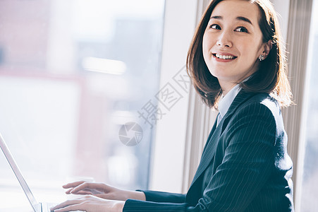 女生西服商人老板女人在靠窗的座位上前往电脑图片