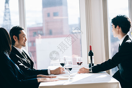 套装一份年轻新雇用的男士在餐厅与老板敬酒图片