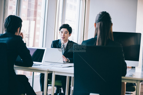 工长后背工作在计算机周围聊天的主管和新员工图片