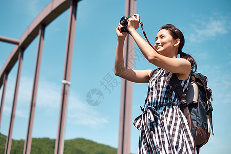 户外旅游拍照的年轻女子图片