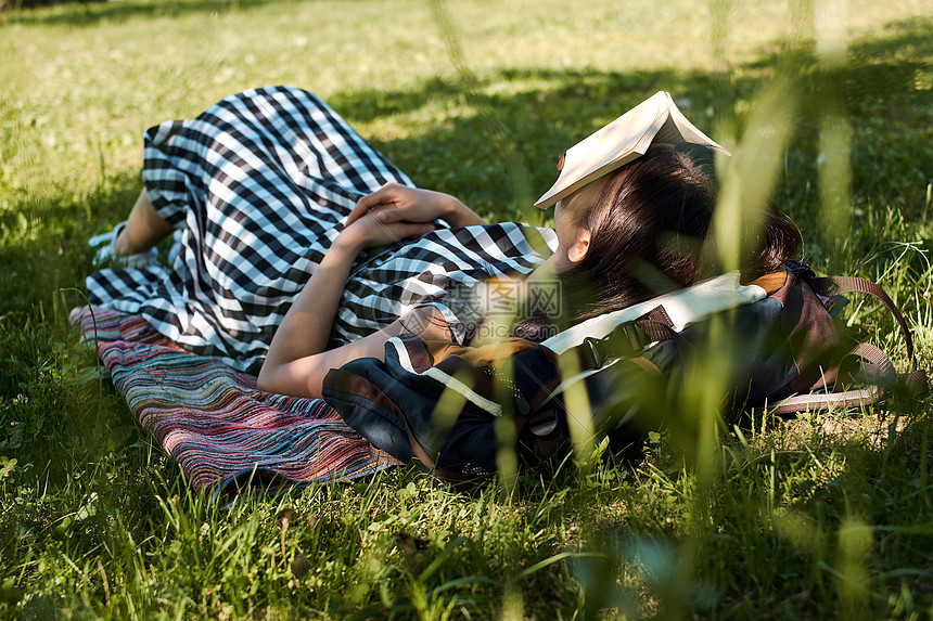 户外草坪上休息的女青年图片