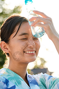 水瓶放在额头降温的年轻女子图片