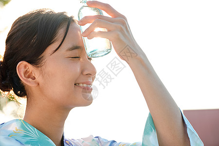水瓶放在额头降温的年轻女子图片