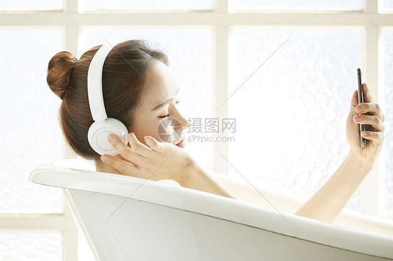 戴着耳机沐浴的年轻女子图片