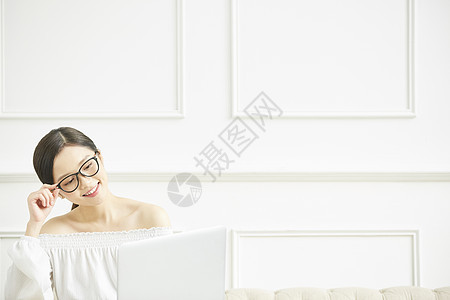 戴黑框眼镜使用电脑的女青年图片
