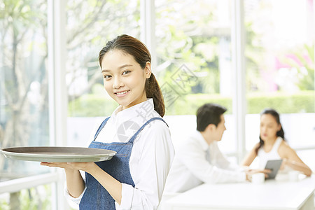 餐厅年轻可爱女服务员端着盘子图片