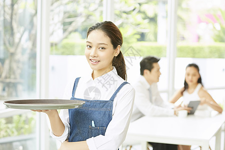 餐厅年轻可爱女服务员端着盘子图片