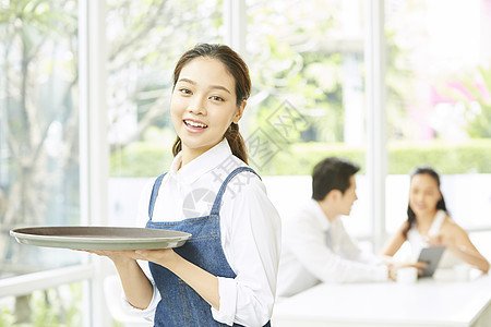 餐厅年轻可爱女服务员端着盘子图片