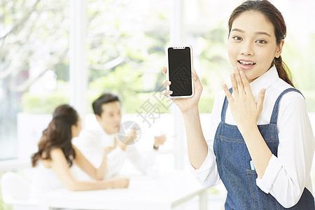 餐厅年轻可爱女服务员拿着手机图片