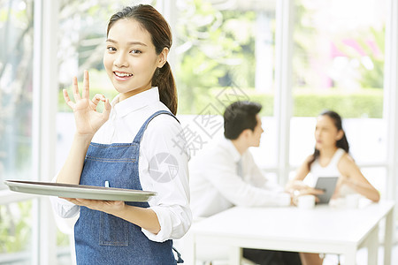 餐厅年轻可爱女服务员端着盘子图片