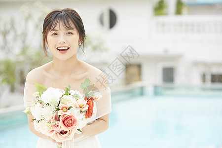 户外泳池边拿着手捧花的新娘图片