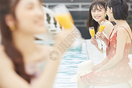 度假酒店泳池的女人喝饮料图片