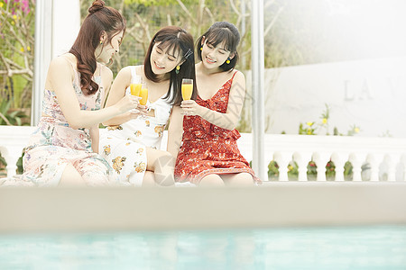 度假泳池的女人聚会喝果汁图片