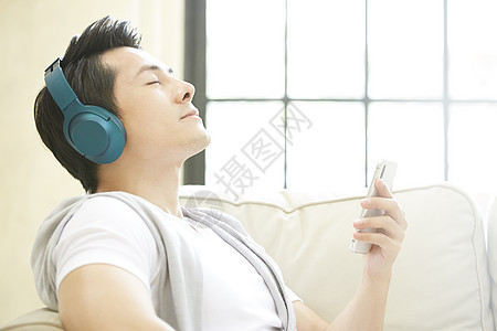 家里沙发上听音乐的男子图片