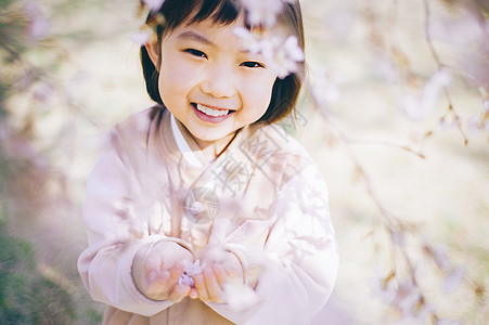 公园里观赏樱花的小女孩图片