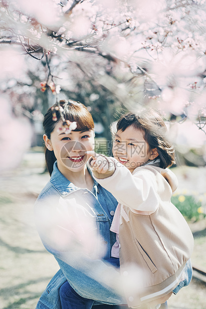 观赏樱花的母亲抱着小女孩图片