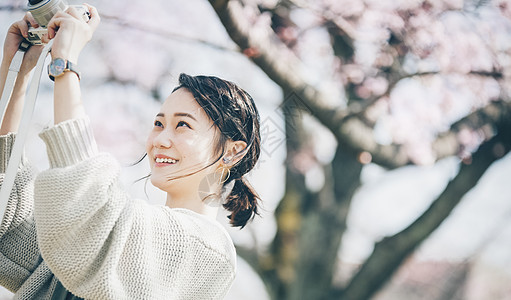 三十几岁即将离开或出去幸福樱花拍照片的春天妇女图片