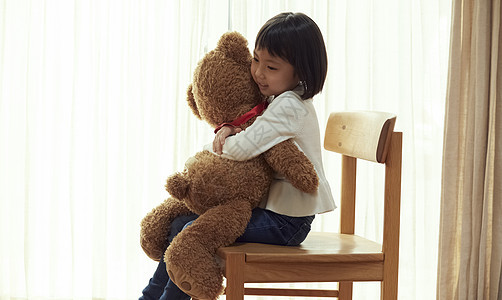 人物礼物坐着使用与一头大熊的女孩坐椅子图片