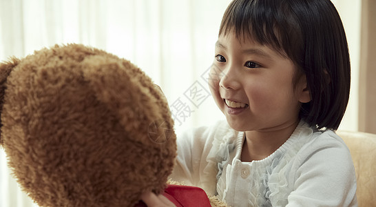 小孩岁少女使用与一头大熊的女孩坐椅子图片