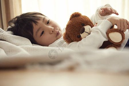 小朋友1人较年轻睡觉与小熊的女孩在床上图片