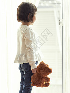 较年轻毛绒玩具玩偶支持一只小熊的女孩窗口图片