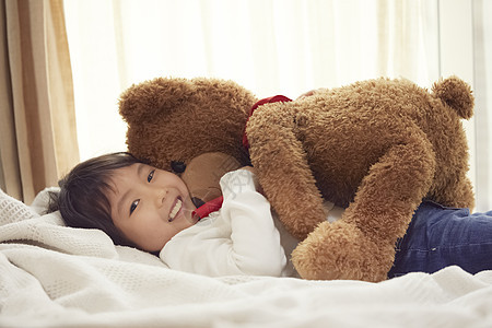 1人孤独的少女睡觉与一头大熊的女孩在床上图片
