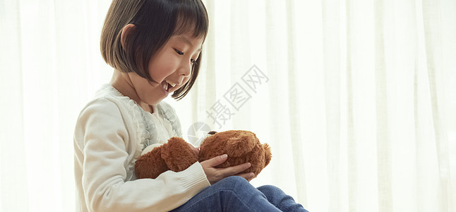 一人学前班岁女孩坐在地板上和玩一只小熊图片