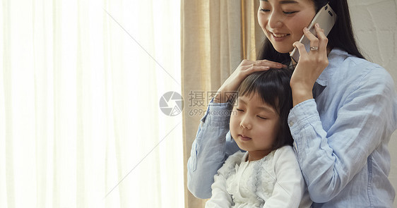 被母亲抱在地板上睡觉的女孩图片