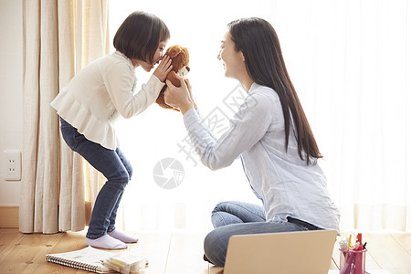 打碎双人父母和小孩使用与在生存地板上的小熊的母亲和女儿图片