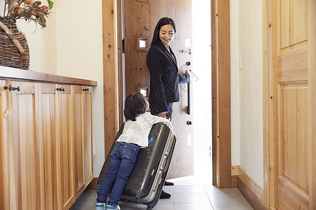 行李箱女子女士们两个人30多岁女儿紧紧抓住母亲的行李箱出门在商务