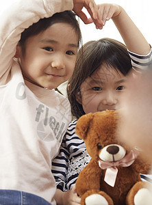 玩偶日本人客厅指向照相机和摆在心脏的孩子图片