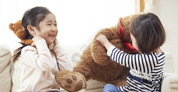 五岁大两个人欢快姐妹们在沙发上玩大熊图片